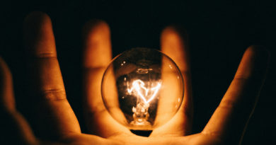 Open innovation e as suas promessas: imagem ilustrativa de uma pessoa segurando uma lâmpada