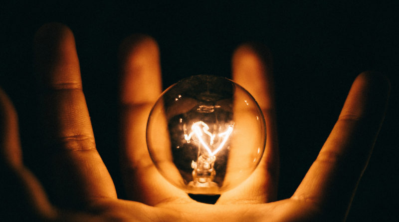Open innovation e as suas promessas: imagem ilustrativa de uma pessoa segurando uma lâmpada